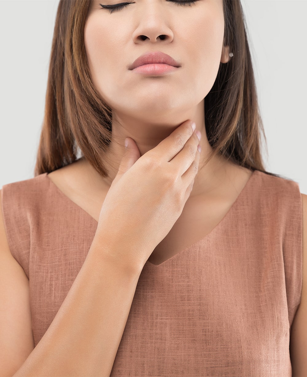 woman touching her thyroid