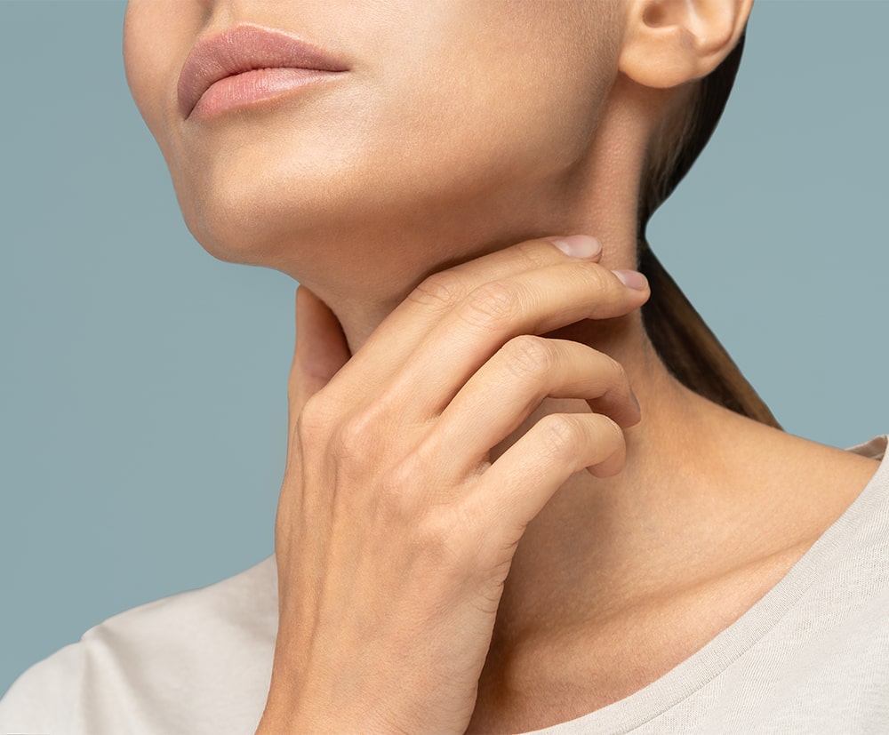 woman touching her thyroid